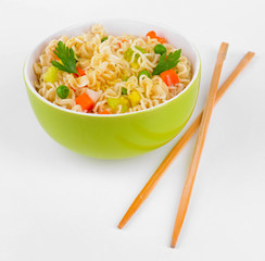 Tasty instant noodles with vegetables in bowl isolated on white