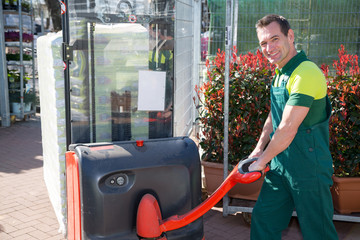 Worker with forklift in warehouse or storehouse