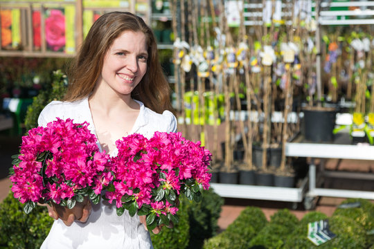 Customer at garden center or flower shop posing with flowers