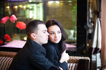 beautiful young couple in love cuddling in restaurant