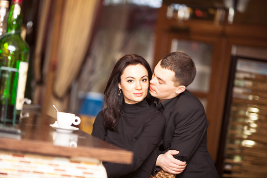 beautiful young couple in love cuddling in restaurant
