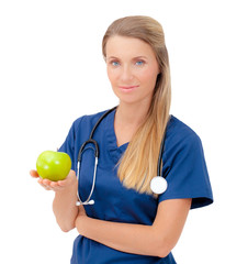 Smiling nurse or young female doctor giving an green apple.