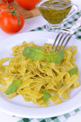 Delicious pasta with pesto on plate on table close-up