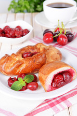 Fresh baked pasties with cherry on plate on table close-up
