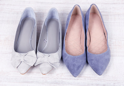 Beautiful grey female shoes on wooden background