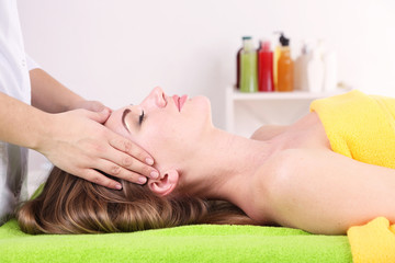 Obraz na płótnie Canvas Beautiful young woman having head massage in spa salon