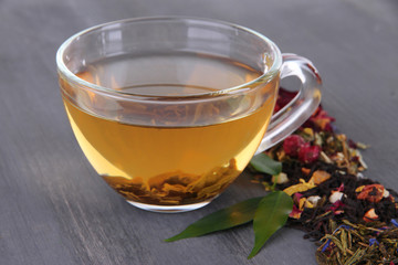 Cup of tea with aromatic dry tea on wooden background