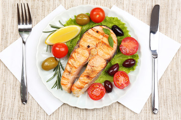 Tasty grilled salmon with vegetables, close up