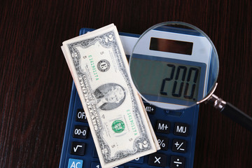 Fraud concept with magnifier and calculator,