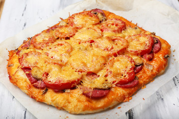 Homemade pizza on baking paper close up