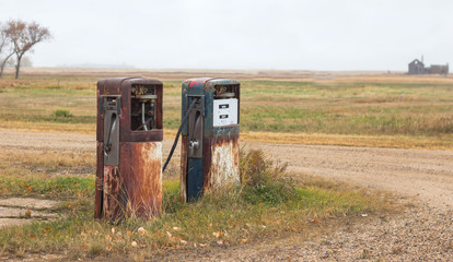 two rusty old abandoned gas pumps