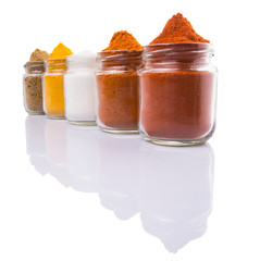 Salt and various spices over white background