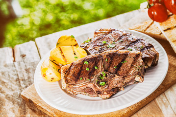 Serving of grilled lamb chops and potato at a BBQ