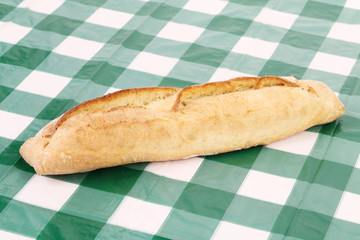 White loaf of bread on the tablecloth.
