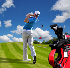 Obraz premium Man playing golf against blue sky with golf bag