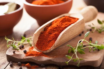 Fotobehang red ground paprika spice in wooden scoop and bowl © Olga Miltsova