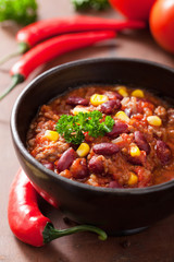 mexican chili con carne in black plate with ingredients