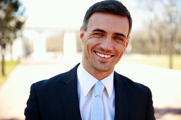 Portrait of a happy handsome businessman on the street