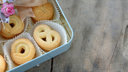 cookie decorated with ribbon in plate on wood floor
