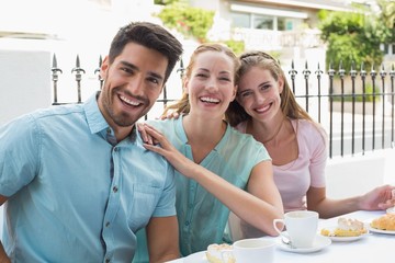 Hhree happy friends having coffee in café