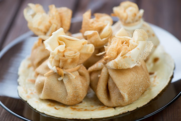 Glass plate with stuffed pancakes, horizontal shot