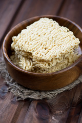 Dry chinese noodles in a wooden bowl, vertical shot
