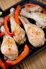 Close-up of baked chicken legs with bell pepper slices