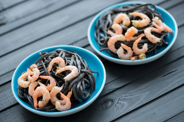 Black tagliatelle with boiled shrimps, horizontal shot