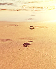 Footprint on sand with waves