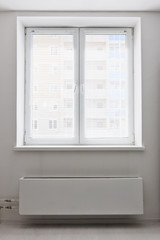 Fototapeta na wymiar White plastic double door window with radiator under it.