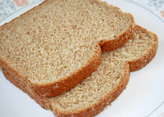 Two slices of fresh whole wheat bread on plate