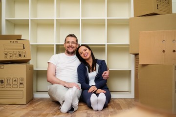 Young positive couple  among boxes in their new home