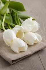 Obraz na płótnie Canvas white tulips on old wood table