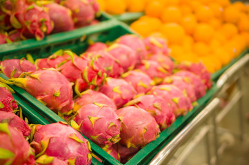 Bunch of dragon fruits - Pitaya and oranges on plastic boxes in