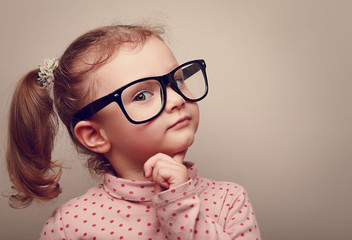 Thinking kid girl in glasses looking. Instagram effect portrait