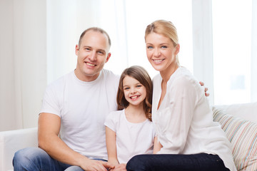 smiling parents and little girl at home