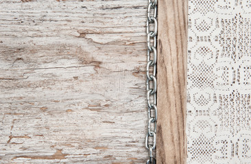 Lace fabric with chain on the old wood