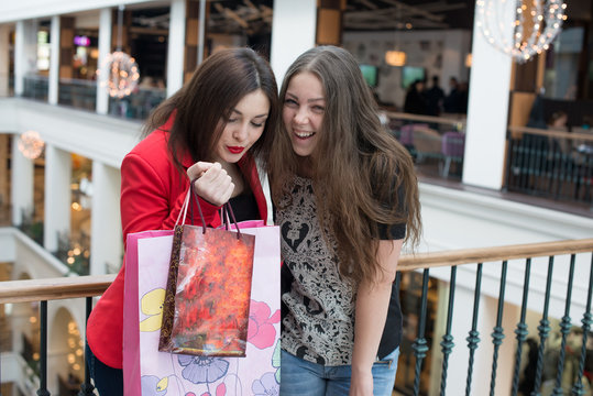 two happy friends shopping in mall