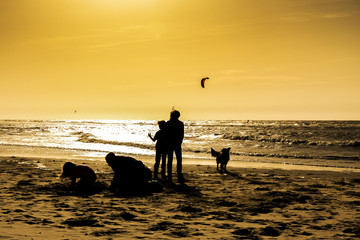 Silhouette of a family while playing by the sea