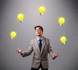 young man standing and juggling with light bulbs