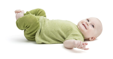 happy toddler lying on his back in green clothing