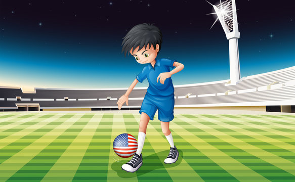 A boy at the field using the ball with the flag of the United St