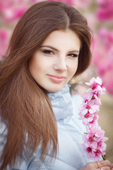 Naklejka premium Happy Teenager girl in spring flowers park