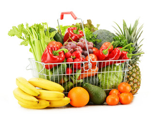 Wire shopping basket with groceries isolated on white