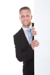 Stylish businessman presenting to a blank sign