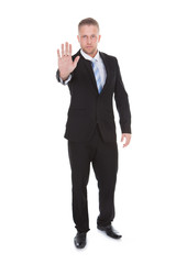 Businessman holding up his hand in a stop gesture