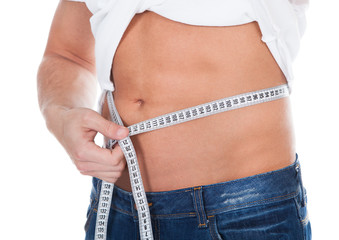 Healthy fit young man measuring his waist