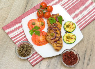 piece of roasted meat on the grill with vegetables and spice