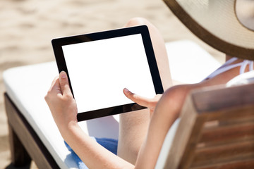 Woman Using Digital Tablet On Beach Chair
