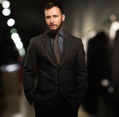 Handsome well-dressed man with beard in a clothing store